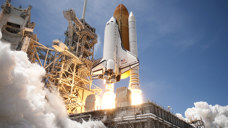 Space shuttle taking off from a launch pad.