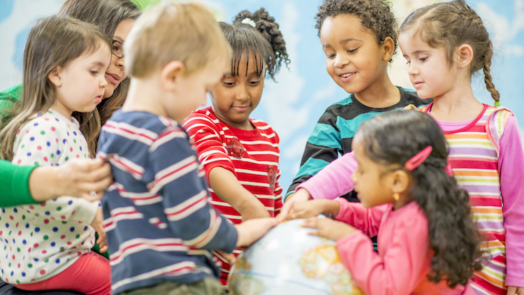 Children pointing at a globe.