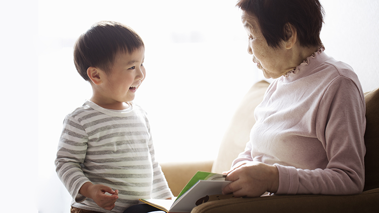 Senior woman and boy reading a book together.