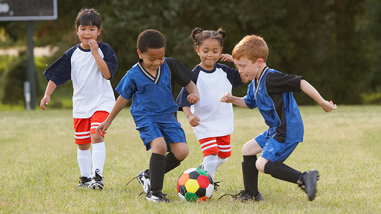 Children playing soccer outdoors