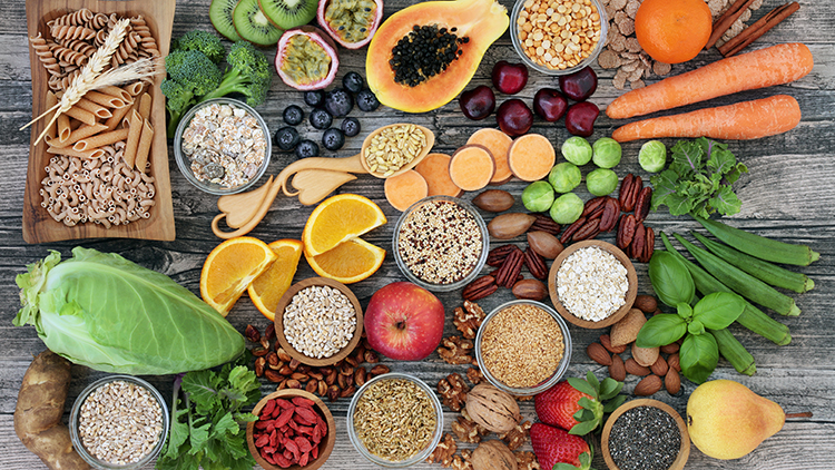 High dietary fibre health food concept with fruit, vegetables, whole wheat pasta, legumes, cereals, nuts and seeds with foods high in omega 3, antioxidants, anthocyanins, smart carbs and vitamins.