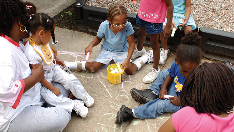 Group of children have a great time with sidewalk art.