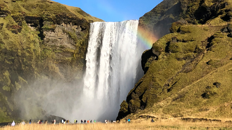 a waterfall with rainbow in Skógafoss, Iceland