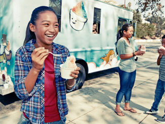 Girl eating ice cream from a truck